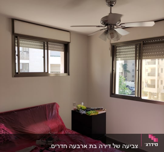 חדר עם מיטה מכוסה בניילון אדום, צבעים על שידה